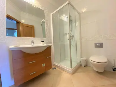 a bathroom with a sink and a shower and a toilet at Apartamento Boavista in Lagos