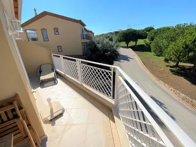 a balcony with a white railing on a house at Apartamento Boavista in Lagos