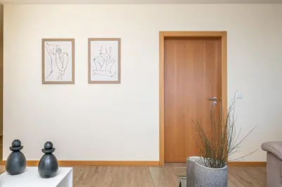 a living room with two drawings on the wall and a door at Canhas Residence II by Homie in Ponta do Sol