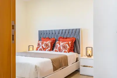 a bedroom with a bed with orange pillows at Canhas Residence II by Homie in Ponta do Sol
