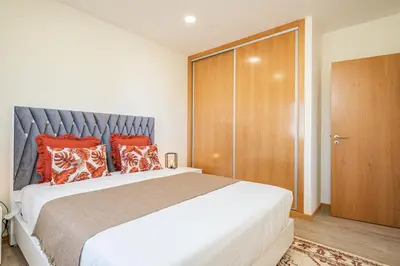 a bedroom with a large bed with red pillows at Canhas Residence II by Homie in Ponta do Sol