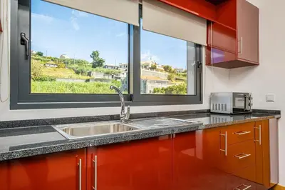 a kitchen with a sink and a large window at Canhas Residence II by Homie in Ponta do Sol