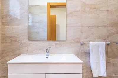 a bathroom with a white sink and a mirror at Canhas Residence II by Homie in Ponta do Sol