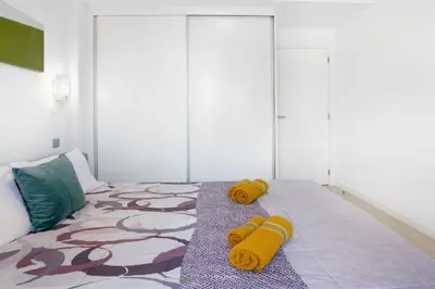 a bedroom with a bed with yellow pillows on it at Recanto Dourado in Porto Santo
