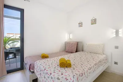 a bedroom with a bed with yellow shoes on it at Recanto Dourado in Porto Santo