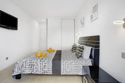 a bedroom with a bed and a flat screen tv at Recanto Dourado in Porto Santo