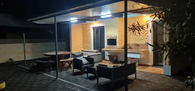 a patio with a table and chairs and an umbrella at Recanto Dourado in Porto Santo