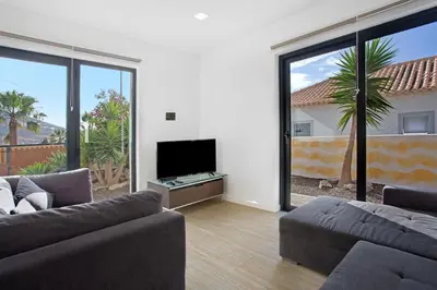 a living room with a couch and a flat screen tv at Recanto Dourado in Porto Santo