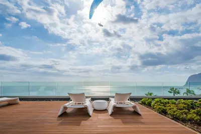 two chairs on a deck with a view of the ocean at Madeira Palace III by An Island Apart in Funchal
