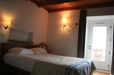 a bedroom with a bed and a television on the wall at Casa de Almagreira - Empreendimento de Turismo em Espaço Rural - Casa de Campo in Vila do Porto