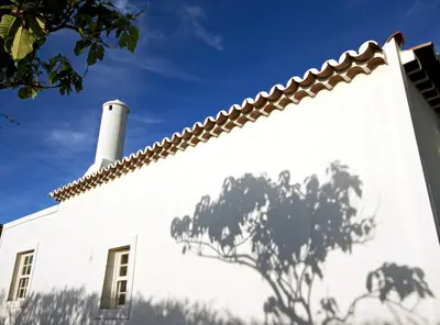 a white building with a chimney on top of it at Casa de Almagreira - Empreendimento de Turismo em Espaço Rural - Casa de Campo in Vila do Porto
