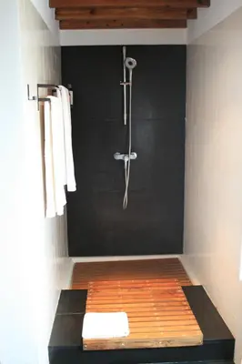 a shower in a bathroom with a black wall at Casa de Almagreira - Empreendimento de Turismo em Espaço Rural - Casa de Campo in Vila do Porto