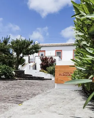 a white building with a sign in front of it at Casa de Almagreira - Empreendimento de Turismo em Espaço Rural - Casa de Campo in Vila do Porto