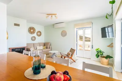 a kitchen and living room with a table with fruit at Aloha Apartment Arrifana in Praia da Arrifana