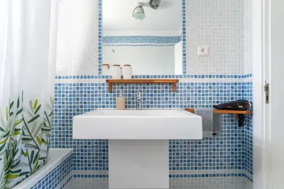 a bathroom with a white sink and blue tiles at Aloha Apartment Arrifana in Praia da Arrifana