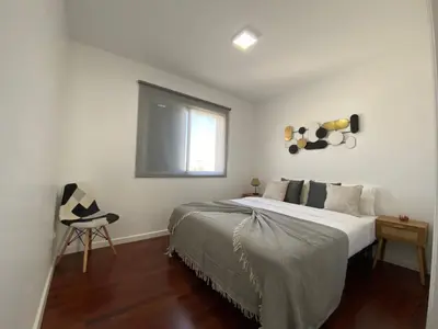 a bedroom with a bed with a window and a chair at Apartamento Oliveira in Funchal