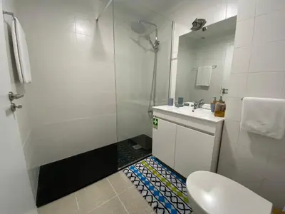 a bathroom with a shower and a toilet and a sink at Apartamento Oliveira in Funchal