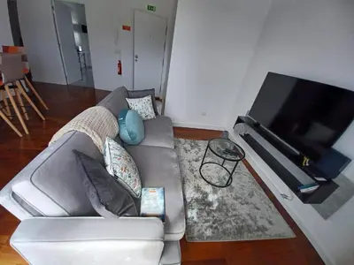 a living room with a couch and a flat screen tv at Apartamento Oliveira in Funchal