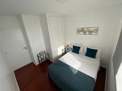 a small bedroom with a bed with blue pillows at Apartamento Oliveira in Funchal