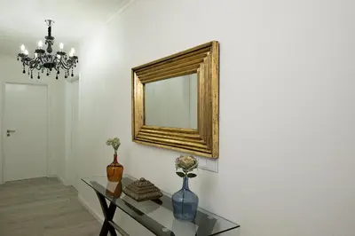 a mirror on a wall with a vase on a table at villa com piscina entre o mar e as montanhas in Paul do Mar