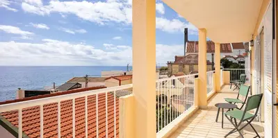 a balcony with chairs and a view of the ocean at villa com piscina entre o mar e as montanhas in Paul do Mar