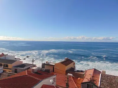 a view of the ocean from the roofs of buildings at villa com piscina entre o mar e as montanhas in Paul do Mar