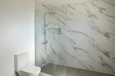 a white bathroom with a toilet and a shower at villa com piscina entre o mar e as montanhas in Paul do Mar