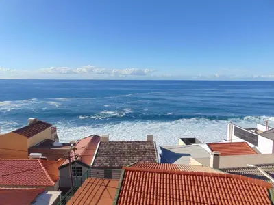 a view of the ocean from the roofs of buildings at villa com piscina entre o mar e as montanhas in Paul do Mar