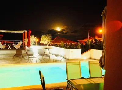 a swimming pool at night with chairs and a table at Casa MaBu by Your Madeira Rentals in Paul do Mar