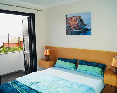 a bedroom with a bed and a large window at Casa MaBu by Your Madeira Rentals in Paul do Mar