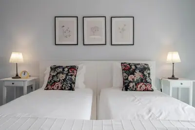 two beds in a white room with two lamps at Garajau I by An Island Apart in Caniço