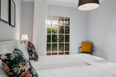 a white bedroom with a large bed and a window at Garajau I by An Island Apart in Caniço
