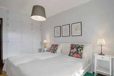a white bedroom with a white bed with two pillows at Garajau I by An Island Apart in Caniço