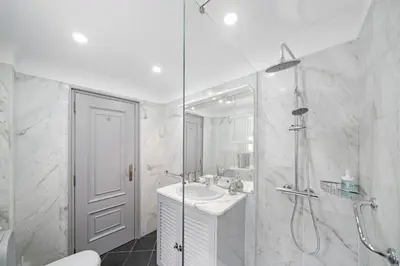 a white bathroom with a shower and a sink at Garajau I by An Island Apart in Caniço