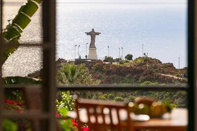 a view of a statue of a cross from a window at Garajau I by An Island Apart in Caniço
