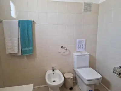 a bathroom with a white sink and a wooden door at Villa Familia Dehoux in Camacha