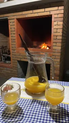 a glass pitcher of orange juice on a table with a glass bowl at Mine House in Calheta