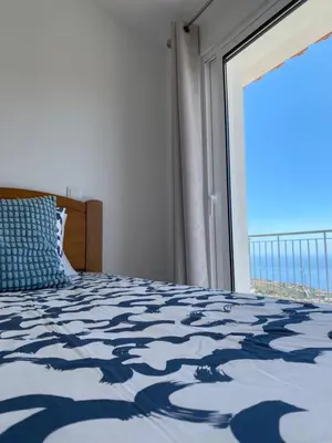 a bedroom with a bed with a view of the ocean at Mine House in Calheta