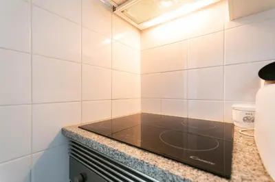 a kitchen with white tiled walls and a counter at Village Lobos Flat in Câmara de Lobos