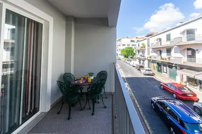 a balcony with a table and chairs and a view of a street at Village Lobos Flat in Câmara de Lobos
