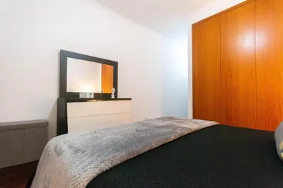 a bedroom with a bed and a flat screen tv at Village Lobos Flat in Câmara de Lobos