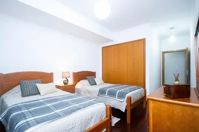 a bedroom with two beds and a mirror at Village Lobos Flat in Câmara de Lobos