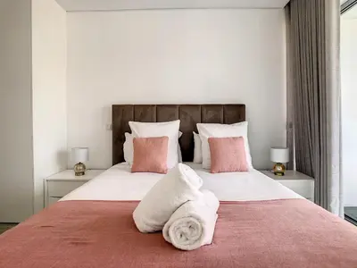 a bedroom with a large bed with pink and white pillows at Uptown Apartment by LovelyStay in Funchal
