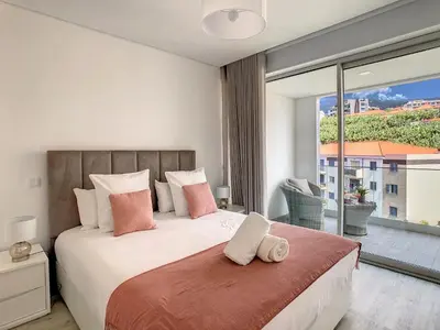 a bedroom with a large bed and a large window at Uptown Apartment by LovelyStay in Funchal