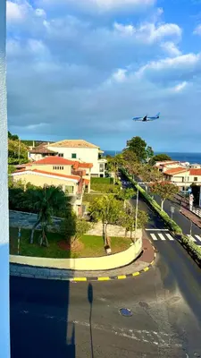 an airplane is flying over a street with a road at Amazing SEA LIGHT Apartment, close to the beach. in Santa Cruz