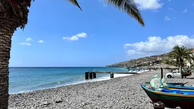 a beach with a boat on the sand and a pier at Amazing SEA LIGHT Apartment, close to the beach. in Santa Cruz