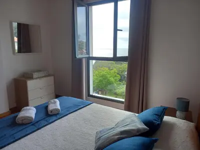 a bedroom with a bed and a large window at Amazing SEA LIGHT Apartment, close to the beach. in Santa Cruz