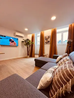 a living room with a couch and a flat screen tv at Living Funchal Executive in Funchal