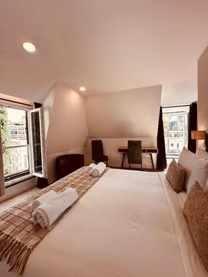 a large white bed in a room with windows at Living Funchal Executive in Funchal