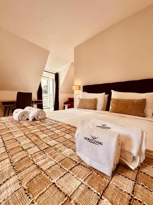 a bedroom with a large bed with towels on it at Living Funchal Executive in Funchal